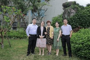 一群男人和女人站在树下描述已自动生成